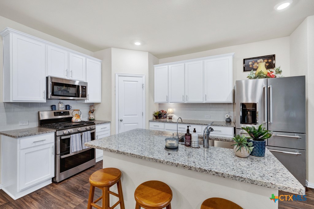 1444 Harwell Loop Kyle, TX 78640 - Photo 9 of 37 a kitchen with granite countertop stainless steel appliances a sink a stove a microwave a refrigerator a stove a microwave and island