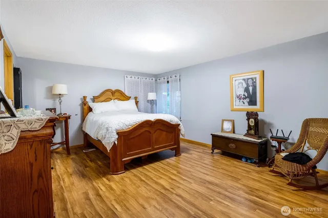 a bedroom with a bed a dresser and chair