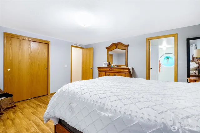 a bedroom with a bed and wooden floor