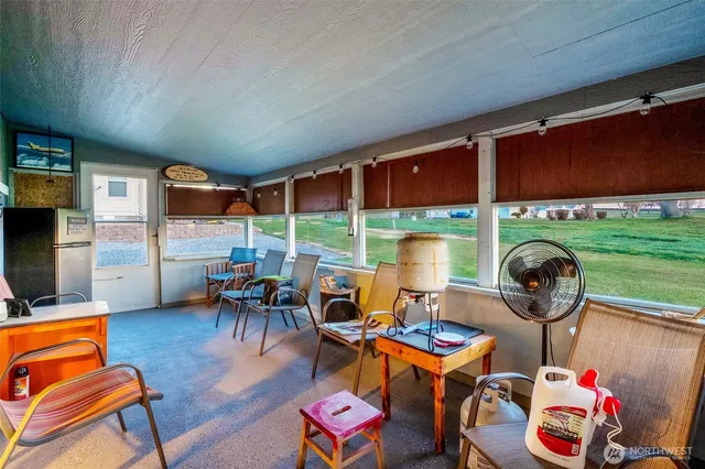 a living room with furniture a rug and a floor to ceiling window