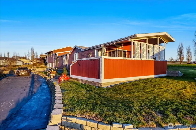 a front view of house with yard and trees in the background