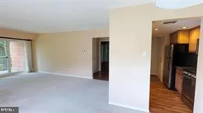 a view of a hallway with wooden floor and a living room