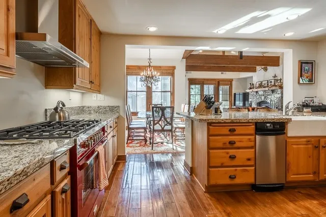 a kitchen with stainless steel appliances granite countertop a stove and a wooden floors