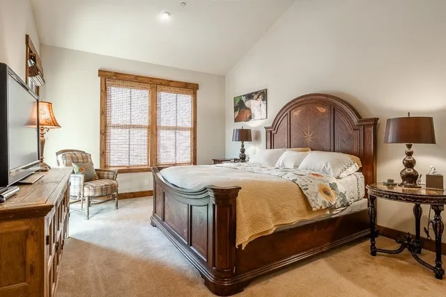 a spacious bedroom with a bed and a flat screen tv