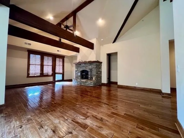 a view of empty room with wooden floor and fireplace