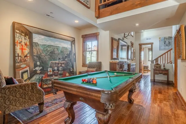a living room with furniture a pool table and a large window