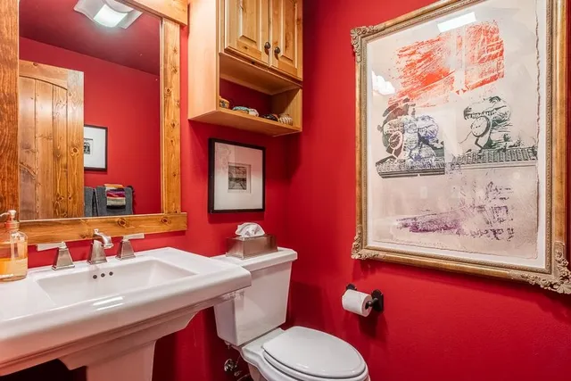 a bathroom with a toilet a sink and mirror