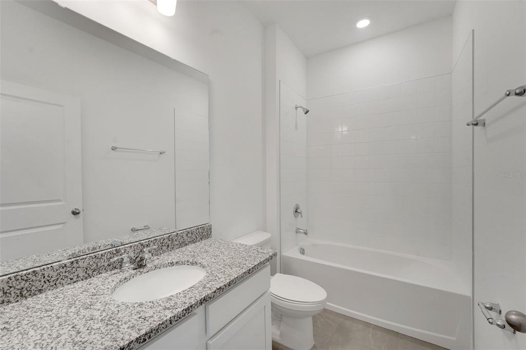 2857 Doolittle Street Tavares, FL 32778 - Photo 13 of 31 a bathroom with a granite countertop sink toilet and shower