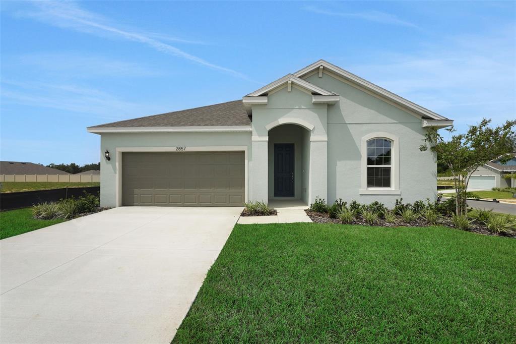 2857 Doolittle Street Tavares, FL 32778 - Photo 2 of 31 a front view of a house with a garden and yard