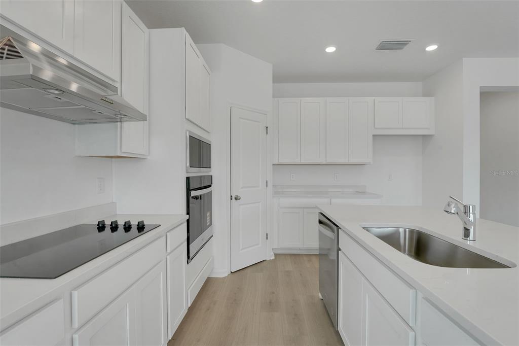 2857 Doolittle Street Tavares, FL 32778 - Photo 24 of 31 a kitchen with a sink cabinets and stainless steel appliances
