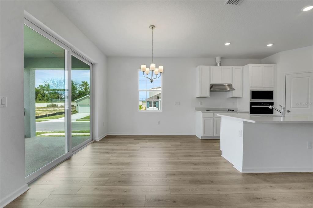 2857 Doolittle Street Tavares, FL 32778 - Photo 27 of 31 a kitchen with stainless steel appliances granite countertop a refrigerator a stove a sink and a window