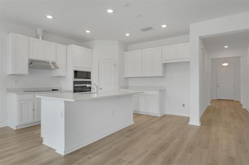 2857 Doolittle Street Tavares, FL 32778 - Photo 5 of 31 a open kitchen with kitchen island white cabinets and stainless steel appliances