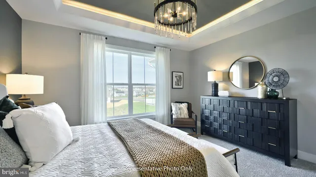 a bedroom with a bed a chandelier and dresser