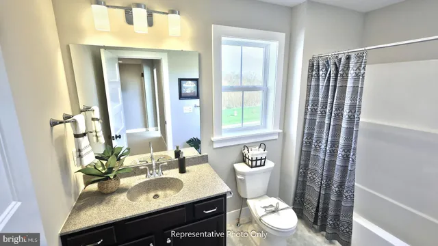 a bathroom with a granite countertop sink toilet a mirror and shower