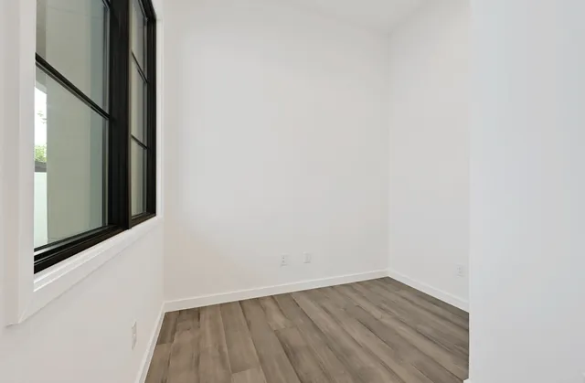 a view of a small space with wooden floor and a window
