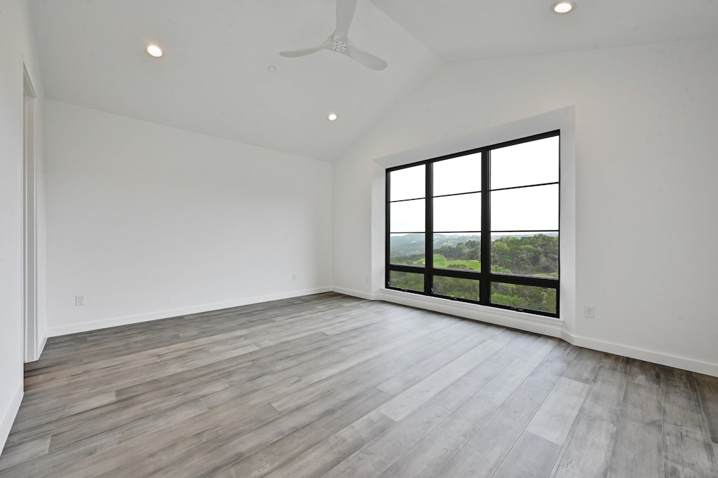 6805 Adeline Way, Unit 17 Austin, TX 78746 - Photo 23 of 38 Unfurnished room with lofted ceiling, recessed lighting, light wood finished floors, and a ceiling fan