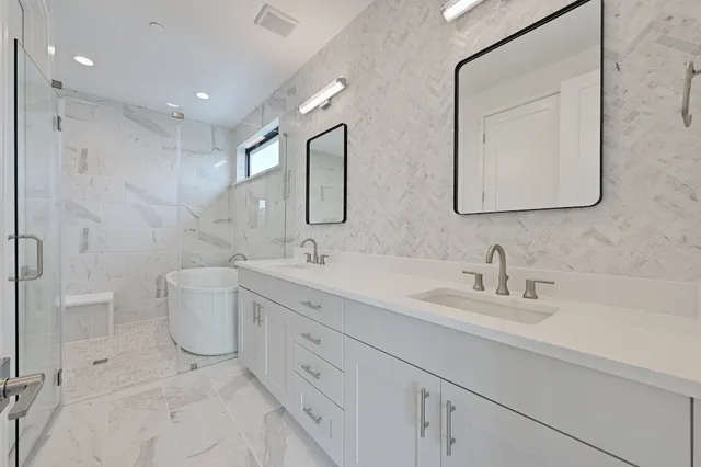 a bathroom with a double vanity sink mirror and toilet