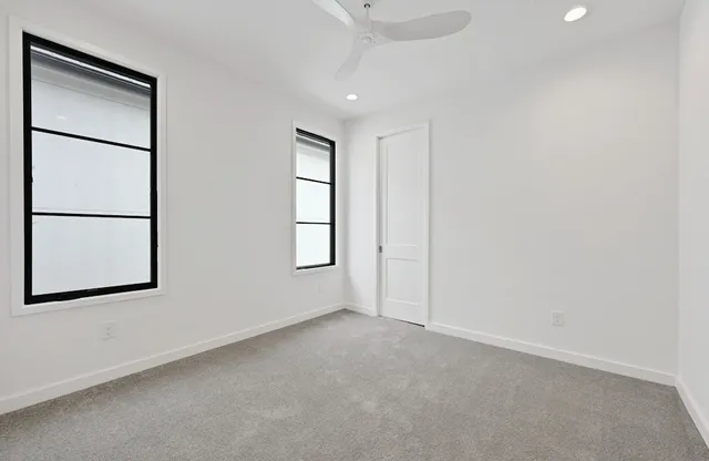 an empty room with windows and closet