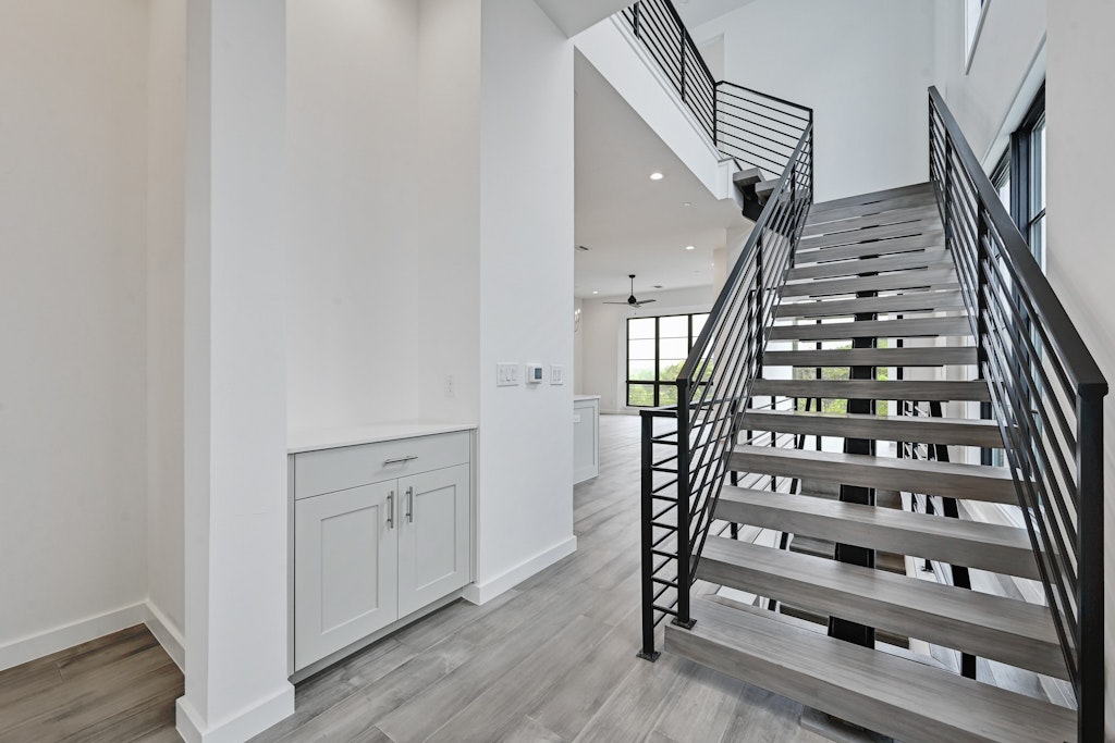 6805 Adeline Way, Unit 17 Austin, TX 78746 - Photo 6 of 38 Staircase featuring recessed lighting, wood finished floors, a ceiling fan, and a high ceiling