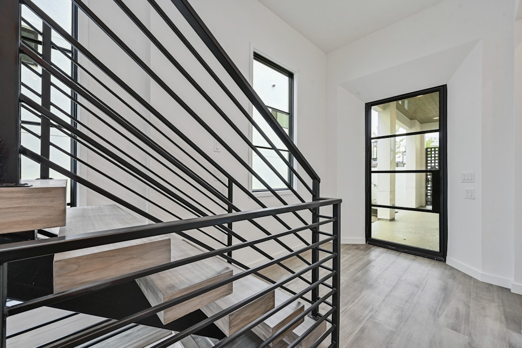 6805 Adeline Way, Unit 17 Austin, TX 78746 - Photo 7 of 38 Staircase with healthy amount of natural light and wood finished floors