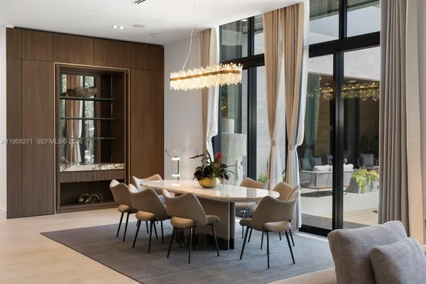 a living room with furniture kitchen view and a chandelier