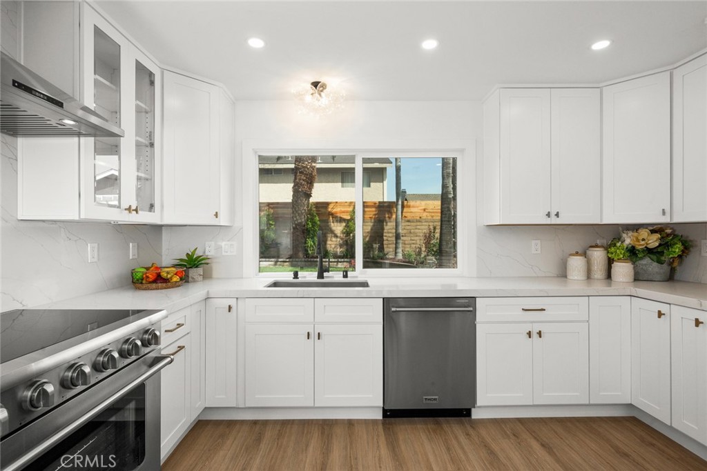 2221 Apple Tree Drive Tustin, CA 92780 - Photo 11 of 30 a kitchen with stainless steel appliances granite countertop a stove and white cabinets