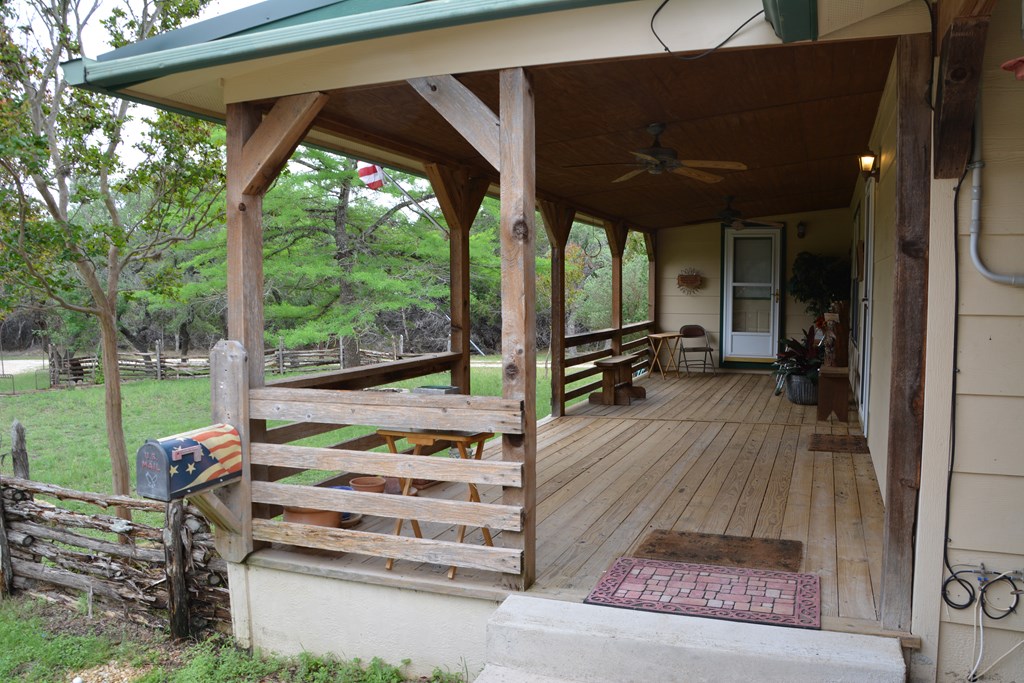 341 Seth Circle Bandera, TX 78003 - Photo 5 of 28 a view of a patio with table and chairs under an umbrella with a small yard