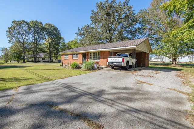 a sign that is sitting on a brick wall next to a building