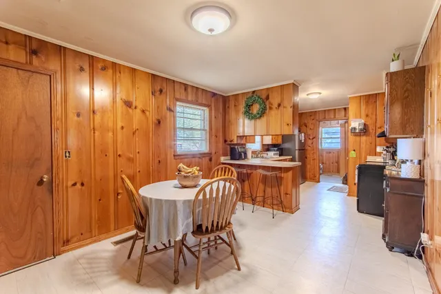 a kitchen with stainless steel appliances kitchen island granite countertop a table chairs in it
