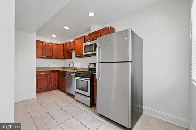 a kitchen with stainless steel appliances granite countertop a refrigerator sink and stove