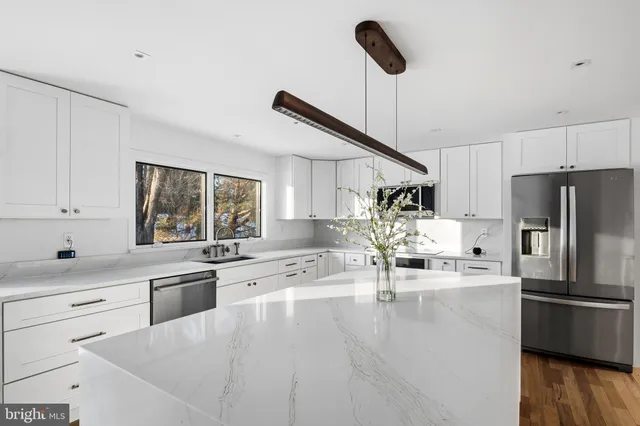 a kitchen with stainless steel appliances granite countertop a sink a stove and refrigerator