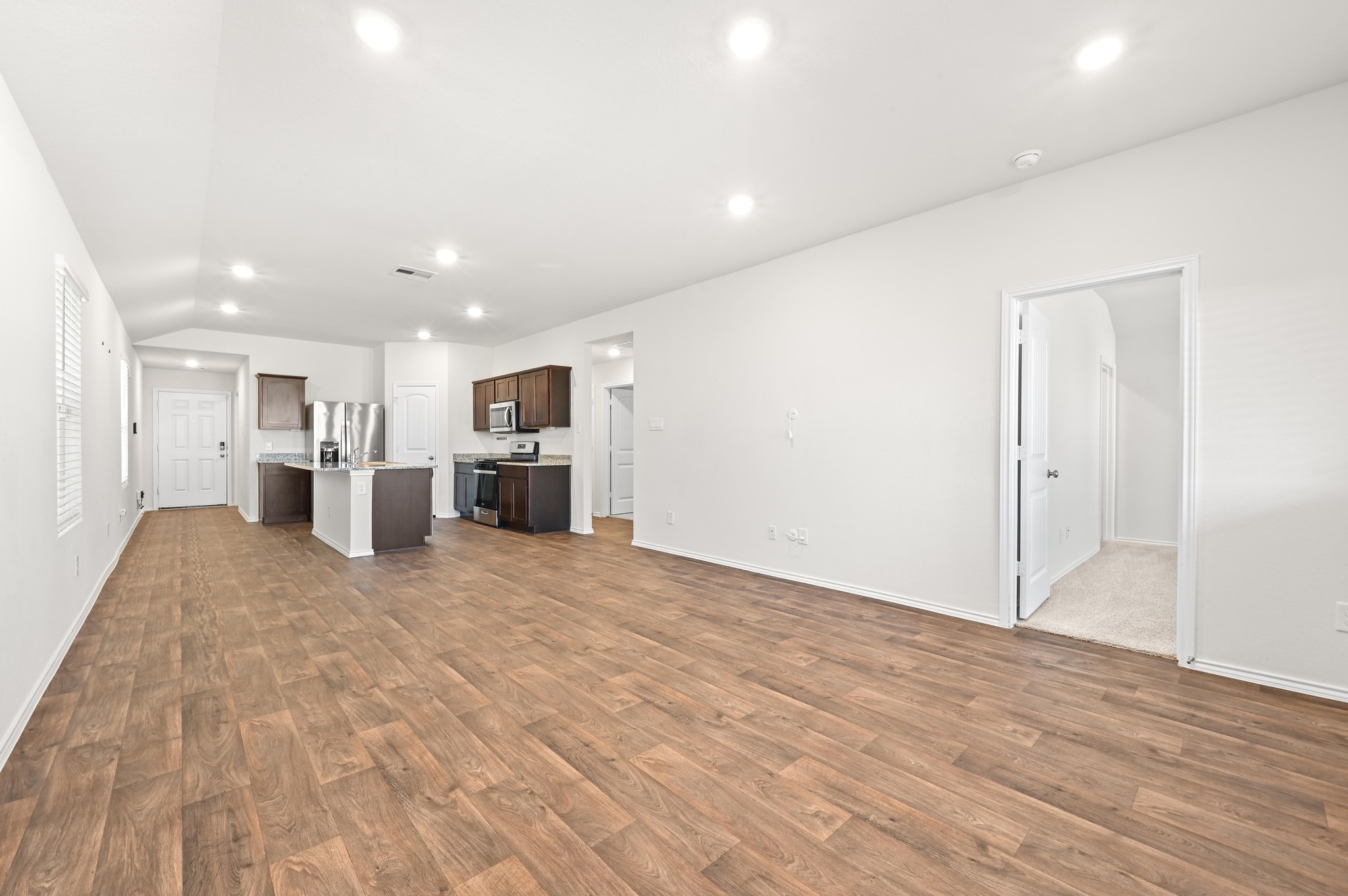 412 Sickle Loop Kyle, TX 78640 - Photo 11 of 25 Unfurnished living room featuring recessed lighting, dark wood-style flooring, and lofted ceiling