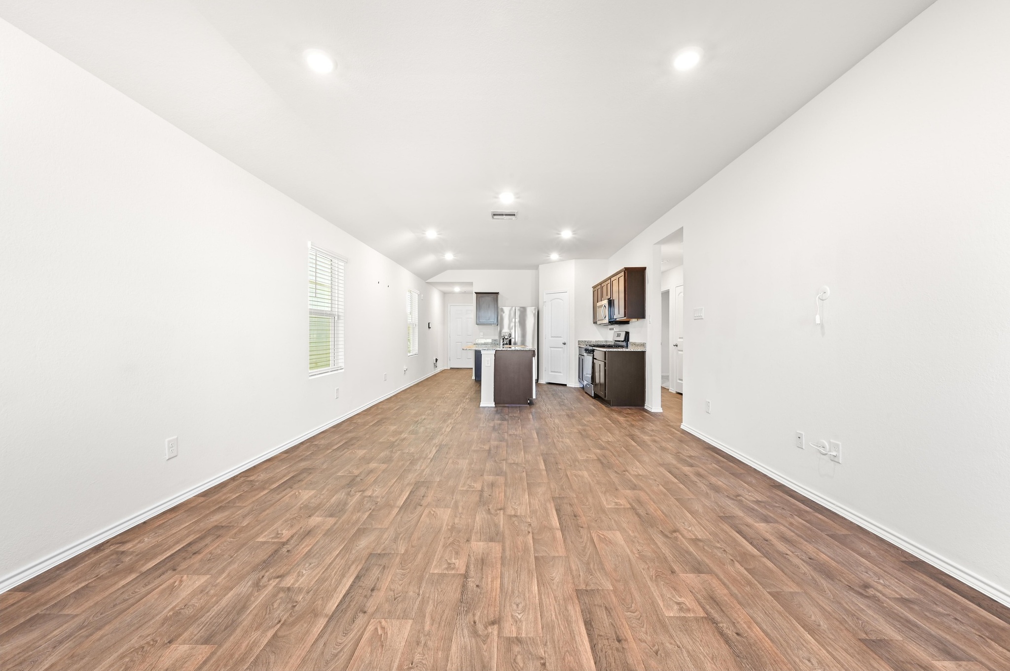 412 Sickle Loop Kyle, TX 78640 - Photo 12 of 25 Unfurnished living room with dark wood-style floors and lofted ceiling