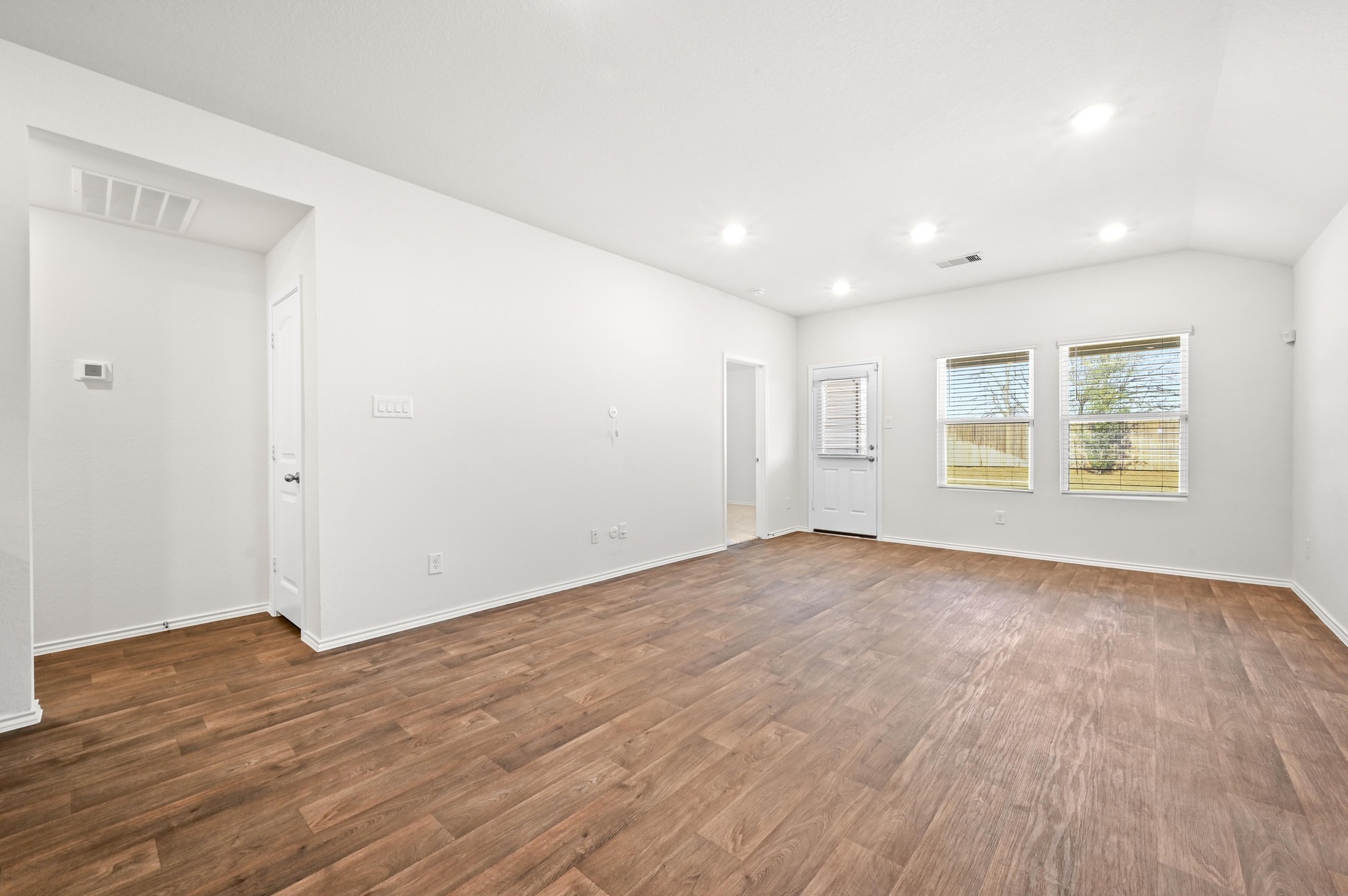 412 Sickle Loop Kyle, TX 78640 - Photo 8 of 25 Unfurnished room with dark wood-style floors, recessed lighting, and vaulted ceiling