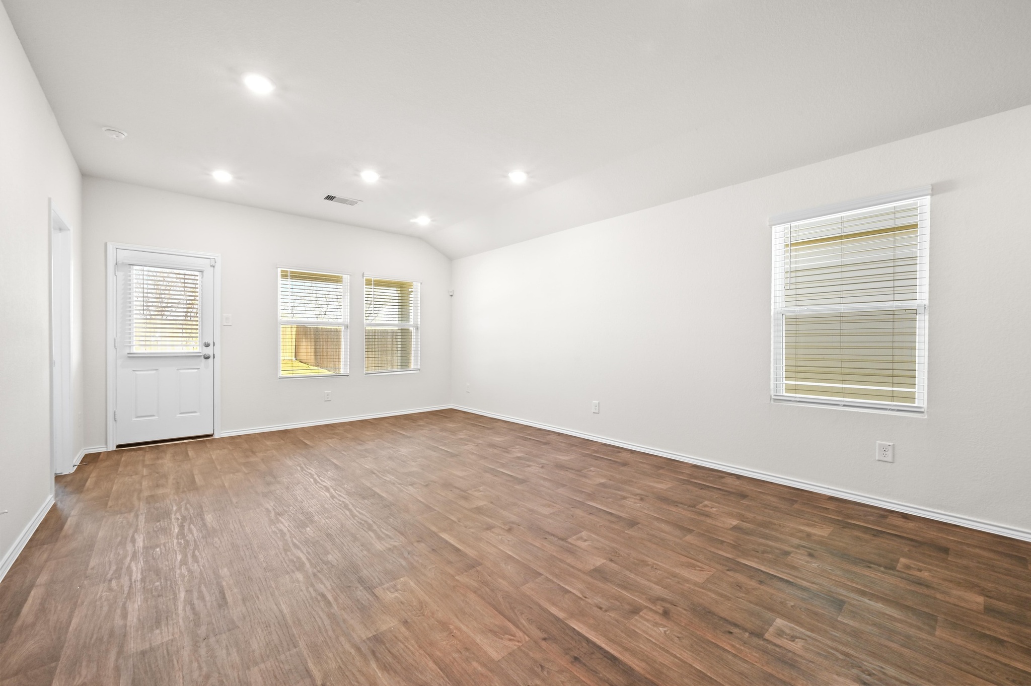 412 Sickle Loop Kyle, TX 78640 - Photo 10 of 25 Unfurnished room featuring dark wood-style flooring, vaulted ceiling, and recessed lighting