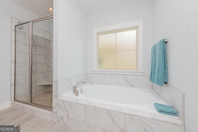 a white bath tub sitting next to a shower