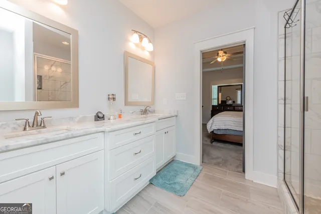 a en suite bathroom with 2 sink flowerpot and a mirror