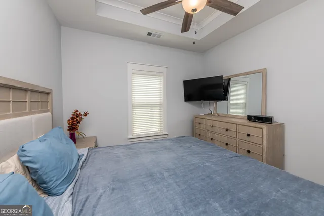 a bedroom with furniture and a flat screen tv