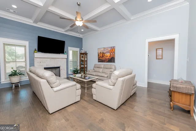 a living room with furniture a flat screen tv and a fireplace