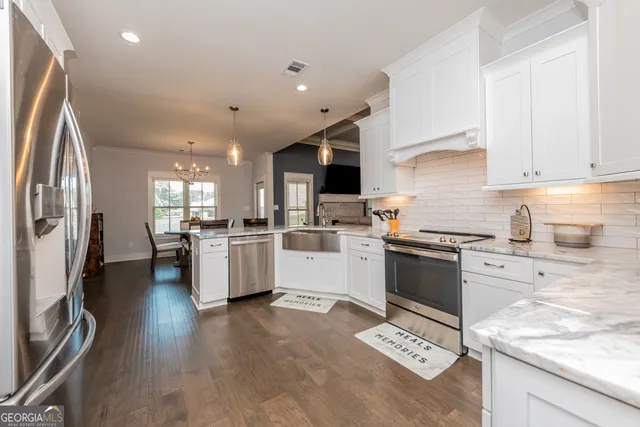 a kitchen with white cabinets and stainless steel appliances