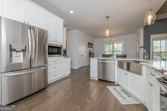 a kitchen with white cabinets and stainless steel appliances