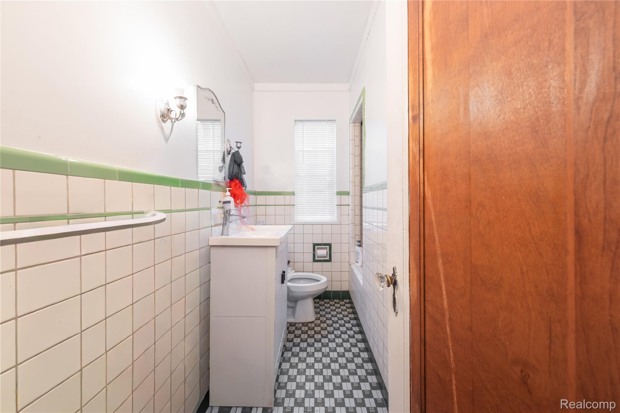 19970 Stratford Road Detroit, MI 48221 - Photo 15 of 27 Bathroom featuring vanity, a wainscoted wall, tile walls, and crown molding