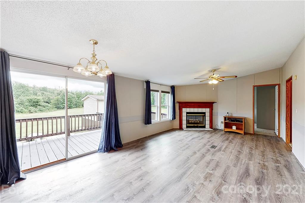 2688 Howells Ferry Road Hickory Grove, SC 29717 - Photo 2 of 43 an empty room with fireplace chandelier and windows