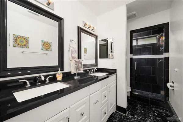 a bathroom with double sink and a mirror