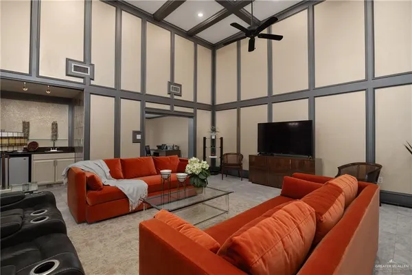 a living room with furniture a flat screen tv and a window