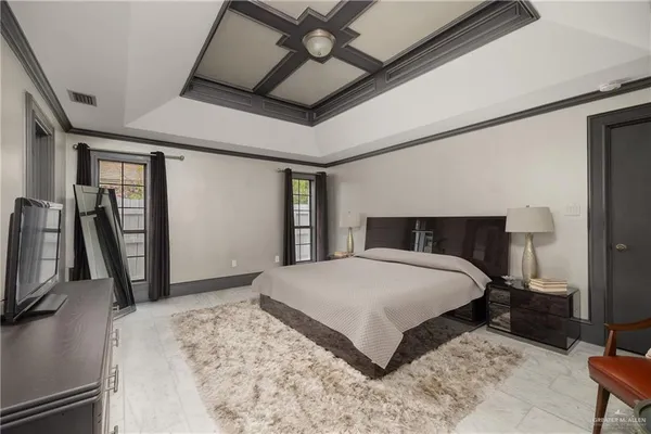 a bedroom with a bed a mirror and dresser