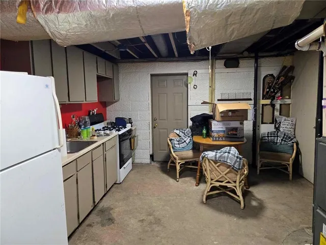 a kitchen with refrigerator and chairs
