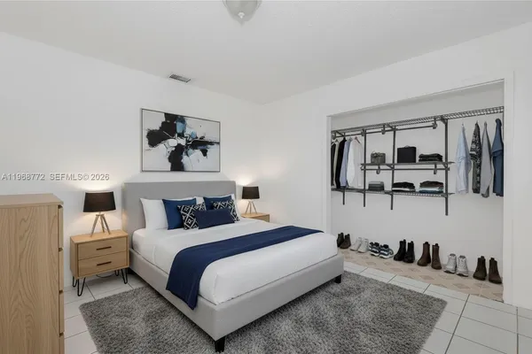 a bedroom with a bed a mirror and night stand