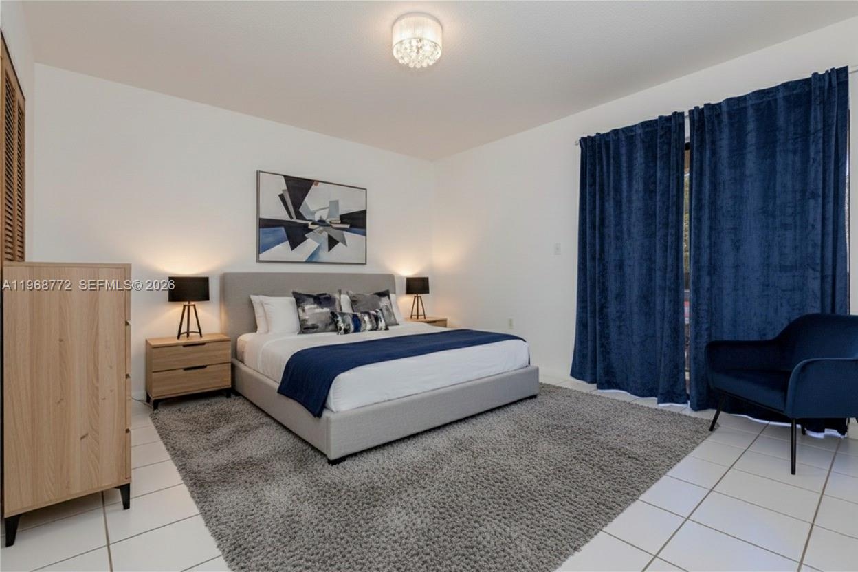 1082 West 79th Street, Unit 25 Hialeah, FL 33014 - Photo 12 of 16 a bedroom with a bed and a chair