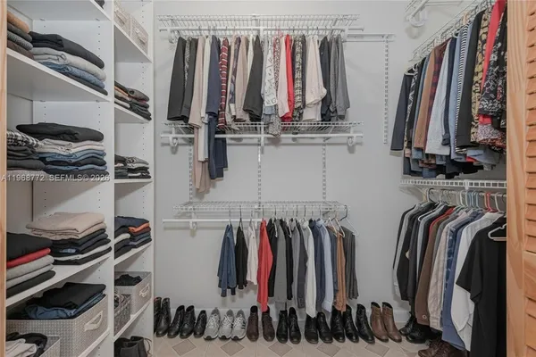 a view of walk in closet with clothes and shoes